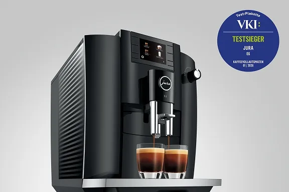 Schwarzer Jura E6 Kaffeevollautomat brüht zwei Espressi. Oben rechts ein blaues VKI-Testsieger-Siegel.